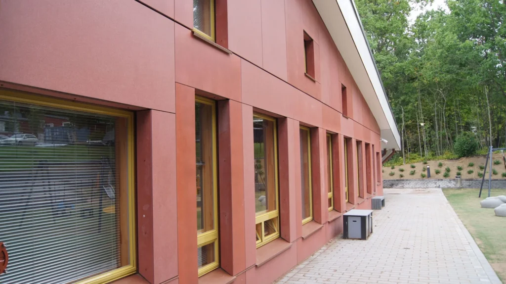 Auroran koulun terrakotanpunainen concrete skin -kuitubetonilevyjulkisivu Allface-piilokiinnityksellä, Espoo