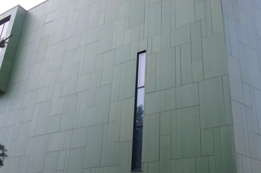 Herttoniemen metrovalvomon vihreä concrete skin -kuitubetonijulkisivu ja kapea pystyikkuna, Helsinki