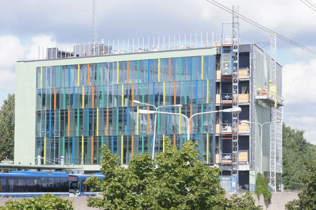 Herttoniemen metrovalvomon värikäs lasijulkisivu ja vihreä concrete skin -julkisivu rakennusaikana, Helsinki