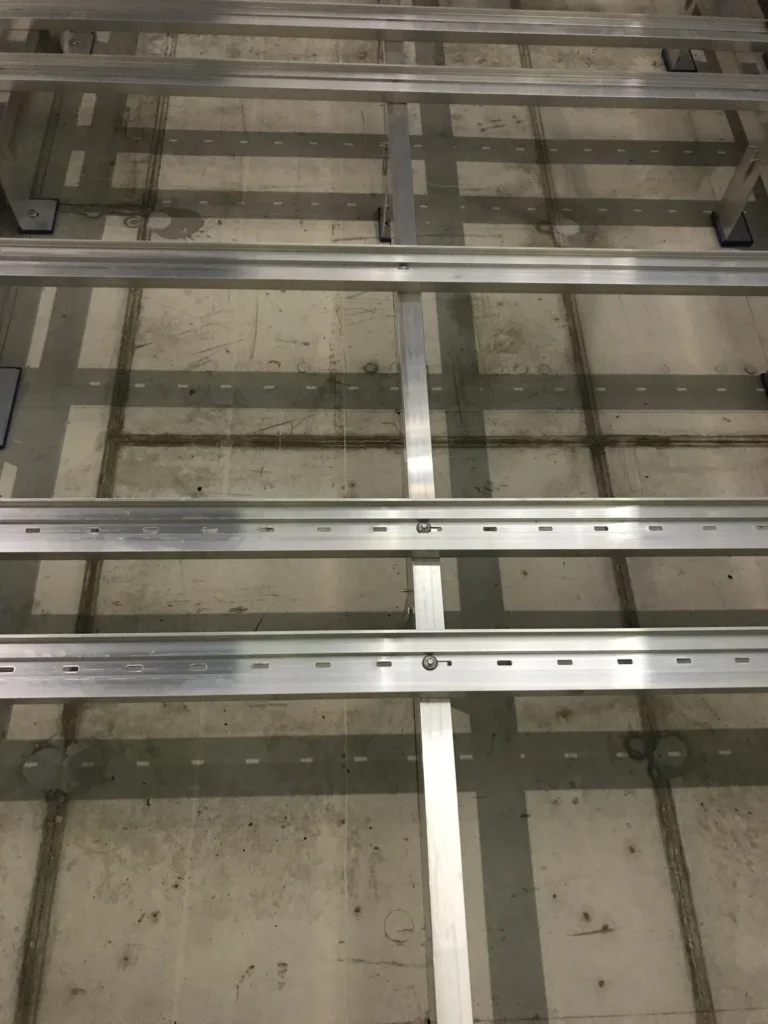 Kivenlahden metron Allface-alumiinirungon vaaka- ja pystyprofiilit betoniseinalla lahikuvassa, Espoo