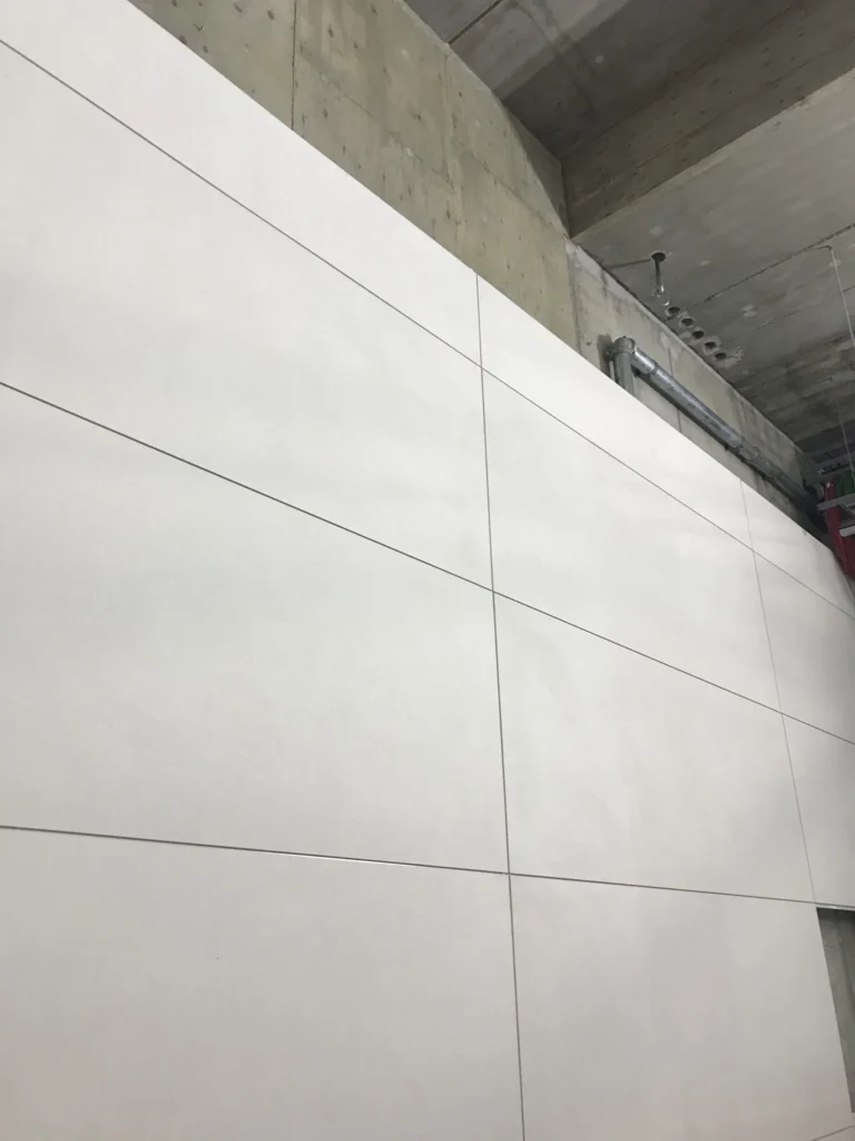 Kivenlahden metron vaalea concrete skin -seinapinta alhaalta kuvattuna, betonikatto ja putket, Espoo