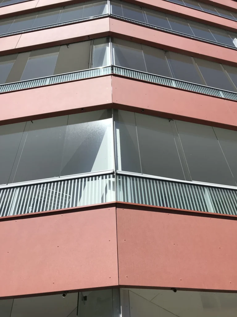 As Oy Koirasaarentie 36:n concrete skin -levyjen nurkkadetalji ja lasitettujen parvekkeiden reunat lahikuvassa, Helsinki