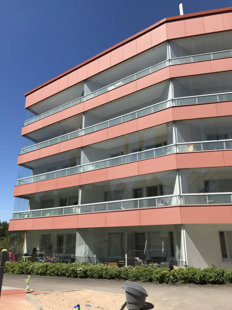 As Oy Koirasaarentie 36:n concrete skin -julkisivu ja lasitetut parvekkeet vinosti alhaalta kuvattuna, Helsinki
