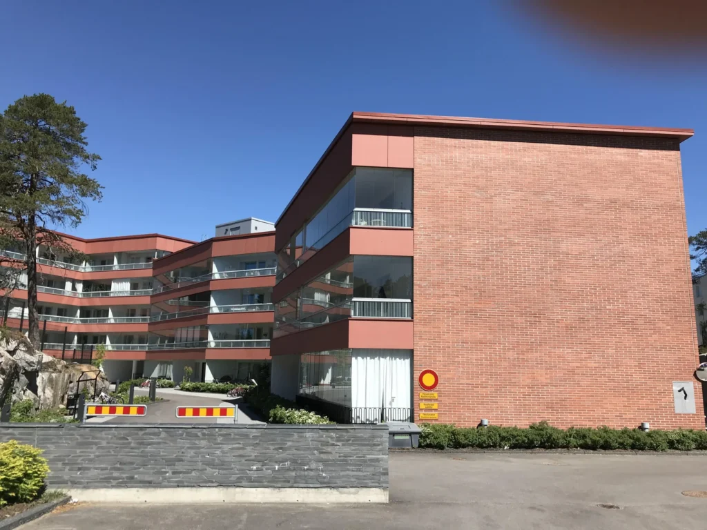 As Oy Koirasaarentie 36:n sisapiha, jossa concrete skin -parvekejulkisivut ja umpinainen tiilipaaty, Helsinki