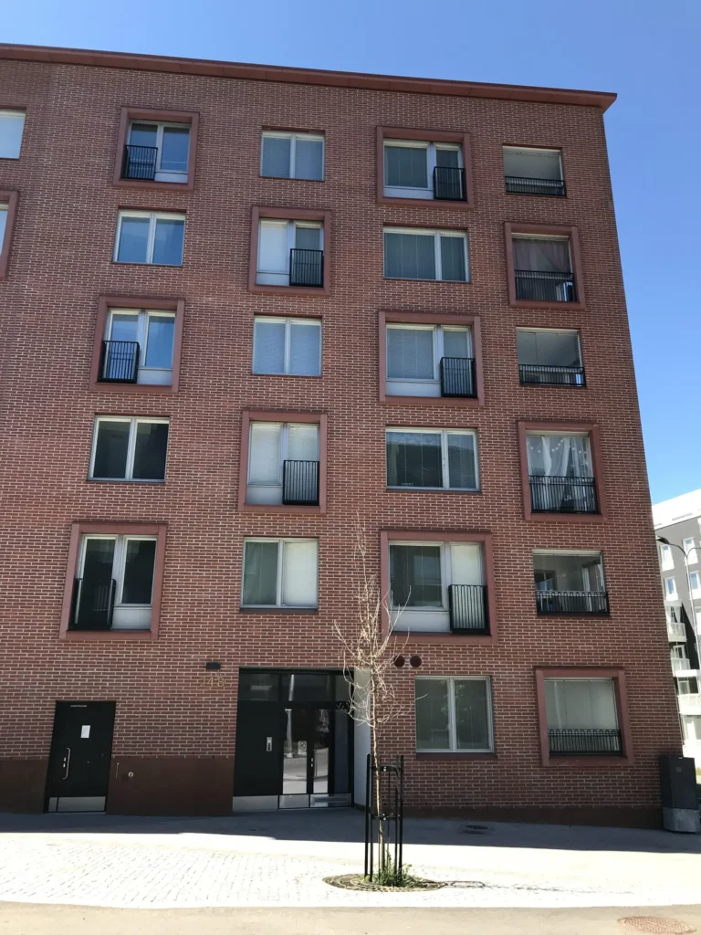 As Oy Koirasaarentie 36:n punatiilisen rakennuksen sisaankaynti ja concrete skin -ikkunapielet, Helsinki