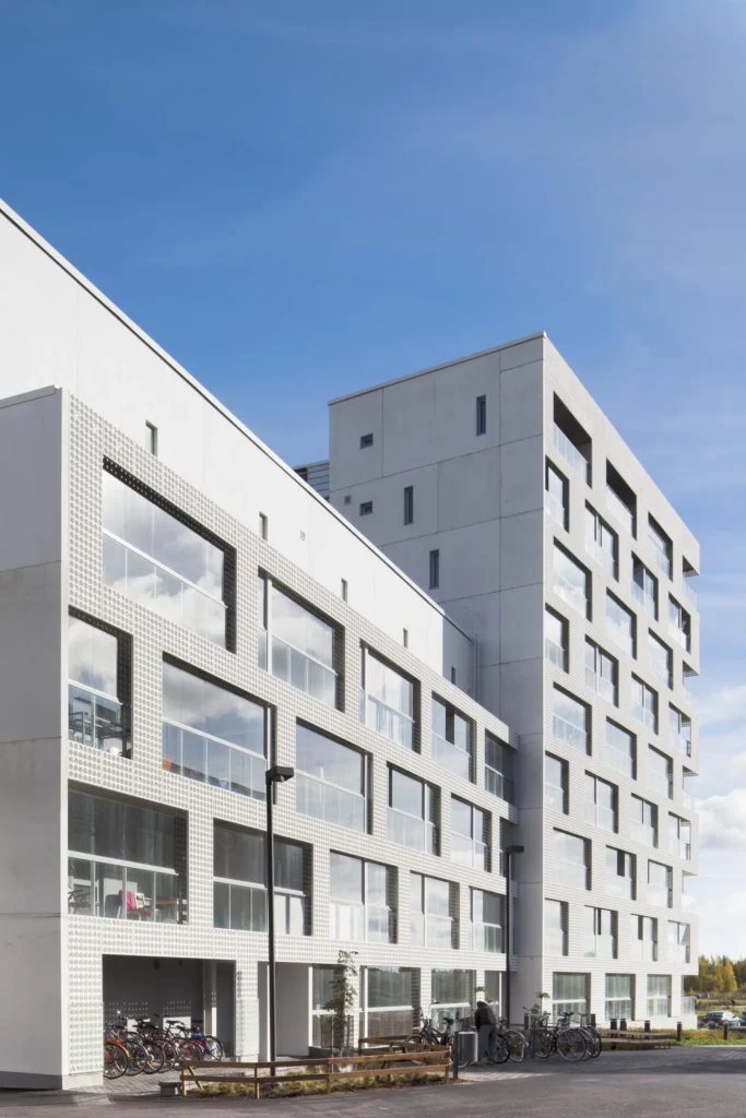Lontoonkatu 9:n cast 3D -julkisivu katutasolta, etualalla polkupyöriä ja istutuksia, Toukolanranta, Helsinki