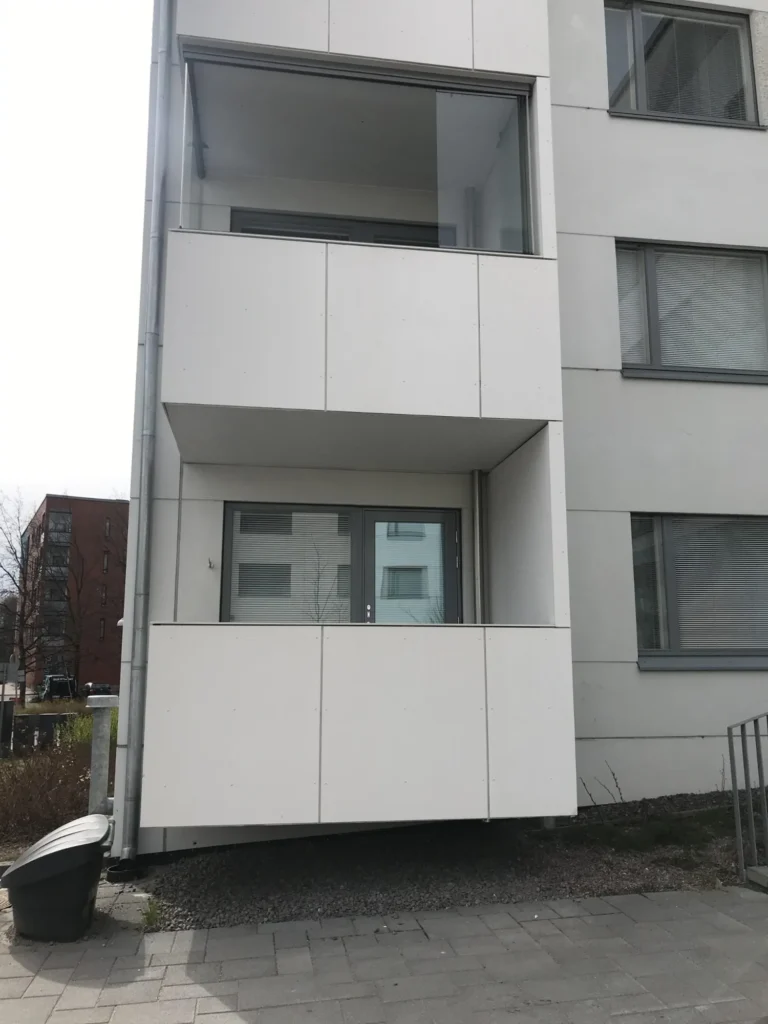 Lähikuva Luutnantinpolku 2:n parvekkeesta ja valkoisista Concrete Skin -julkisivulevyistä asuinkerrostalon julkisivussa