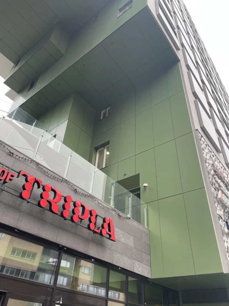 Mall of Triplan sisäänkäynnin yläpuolinen vihreä ALUCOBOND julkisivu ja harmaa kivipinta Pasilassa Helsingissä