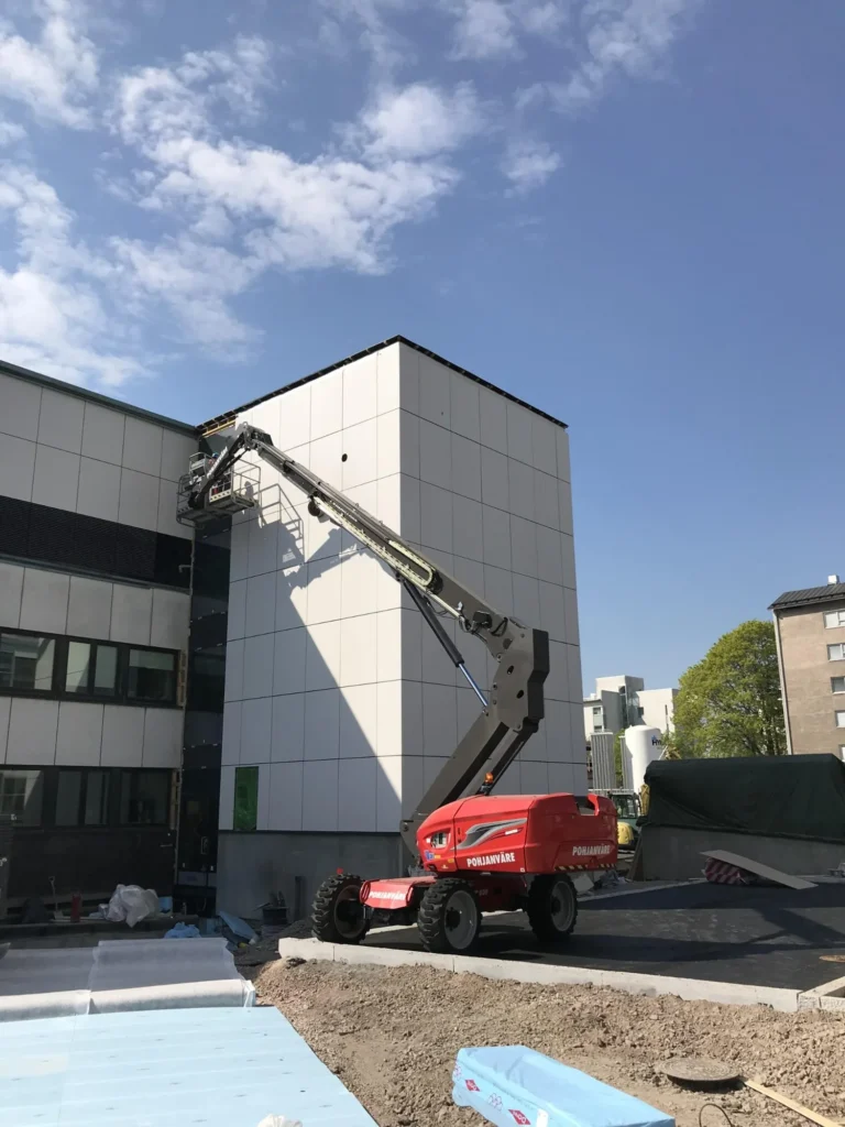 Syöpäklinikan vaalea concrete skin julkisivu ja nostin työmaavaiheessa Meilahdessa