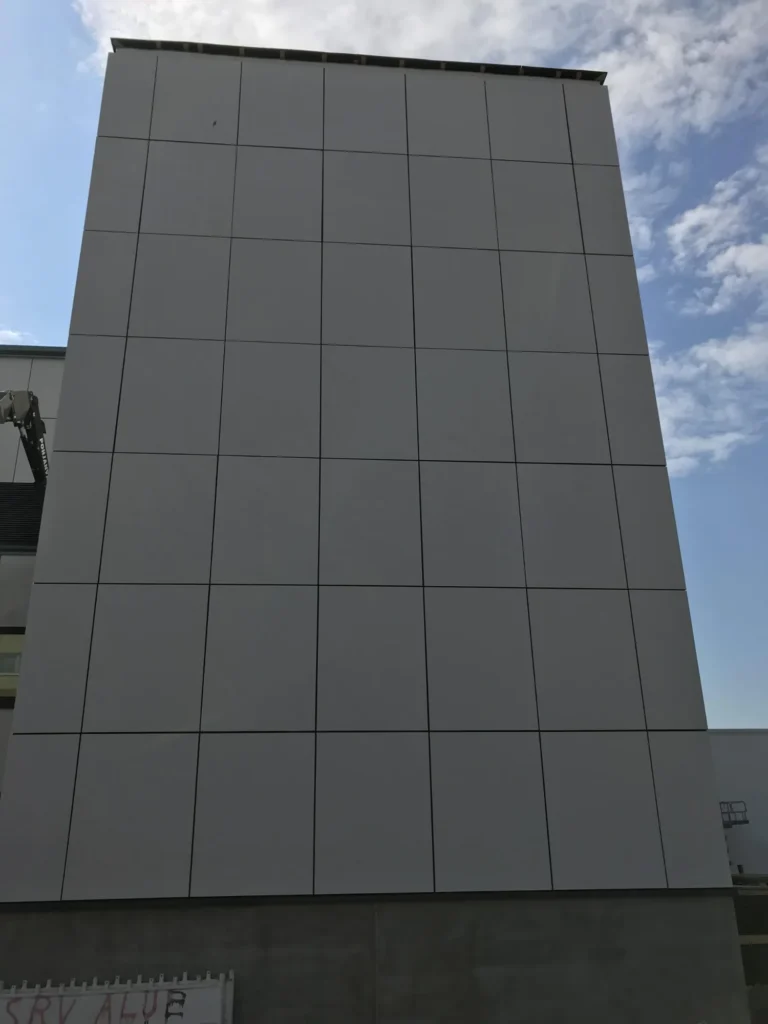 Lähikuva Syöpäklinikan concrete skin julkisivun nurkasta ja vaaleasta kuitubetonipinnasta
