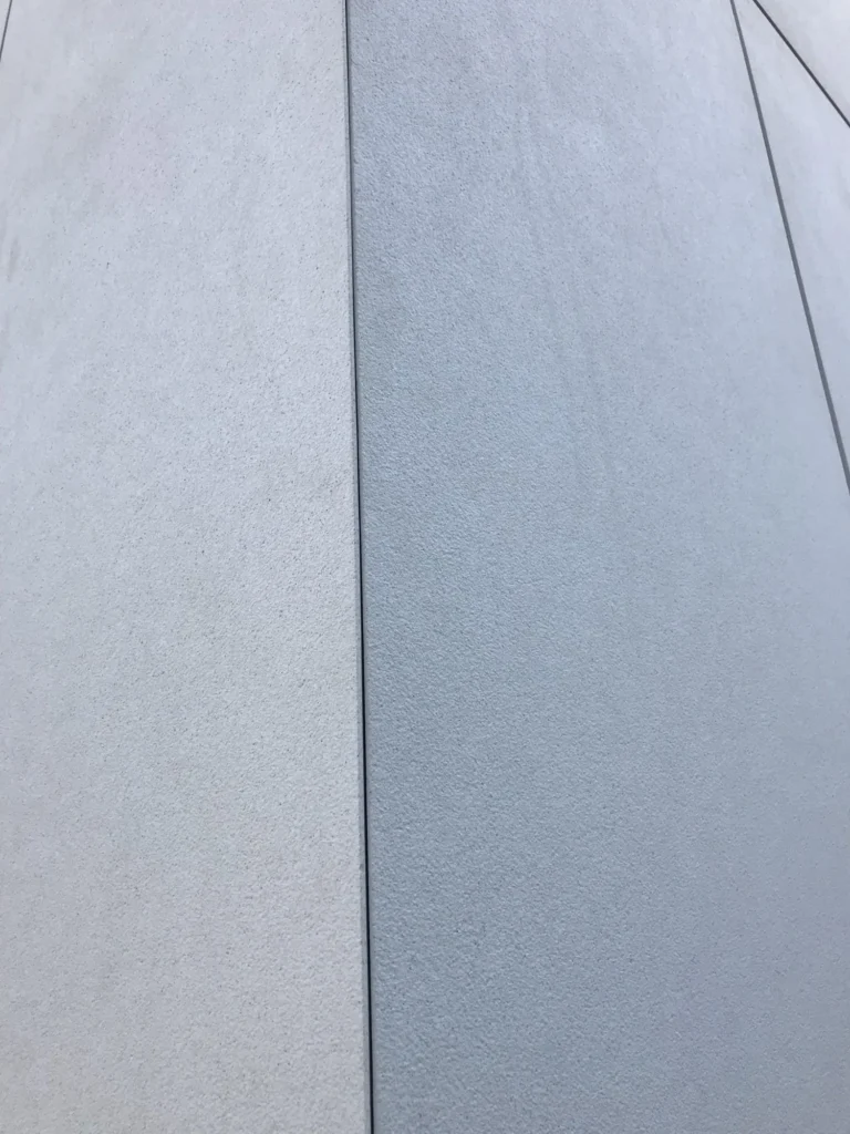 Lähikuva Syöpäklinikan concrete skin julkisivulevystä, hienorakeinen pinta ja pystysauma